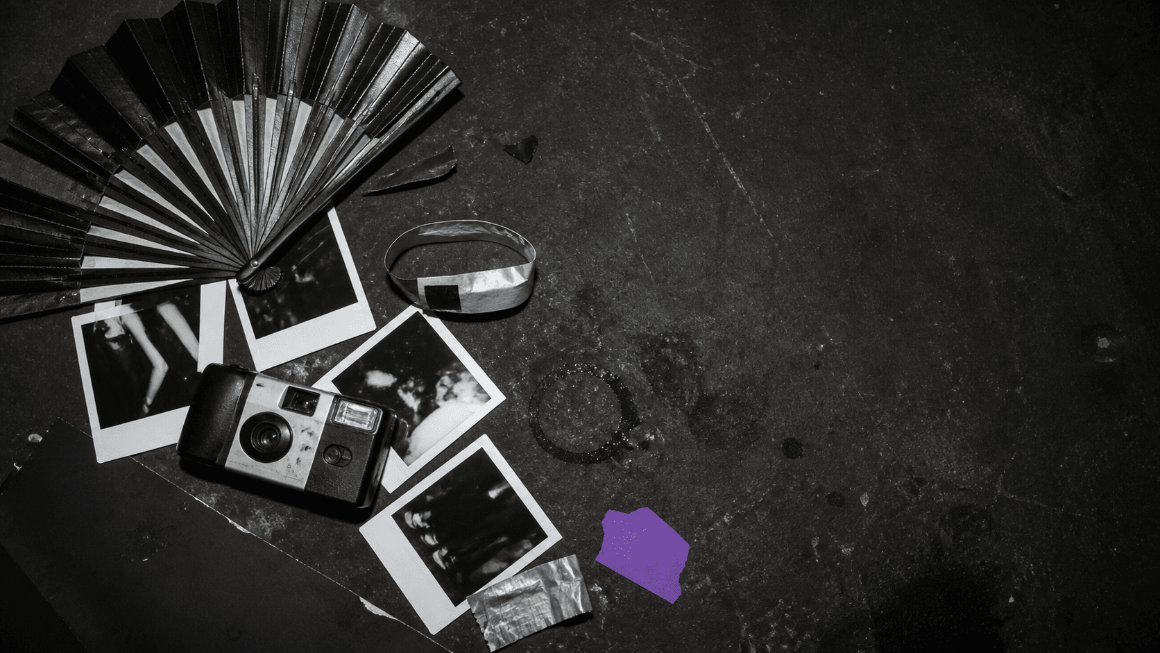 Tavolo di una serata con foto, bicchieri e dettaglio viola